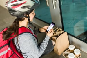 Lieferfahrerin bestätigt die Bestellabgabe über die FoodGenius Fahrer-App.