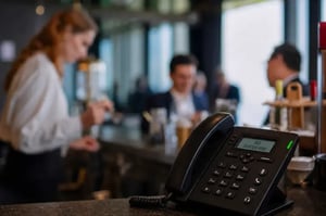 Kellnerin bedient Gäste im Lokal, während eingehende Anrufe vom FoodGenius KI-Telefonassistent entgegengenommen werden.